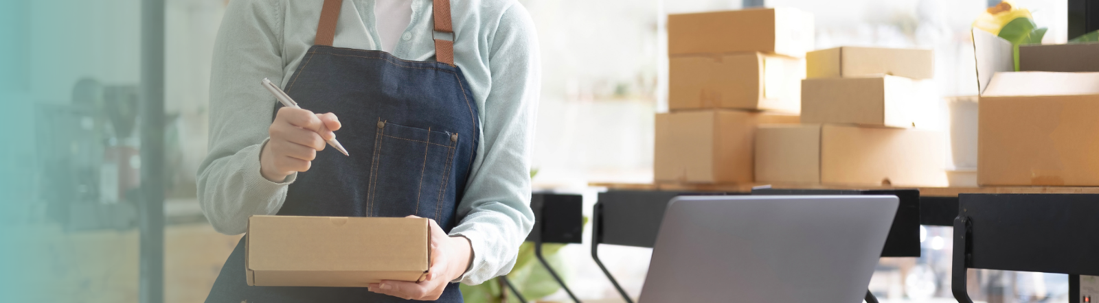 female writes address on small shipping box