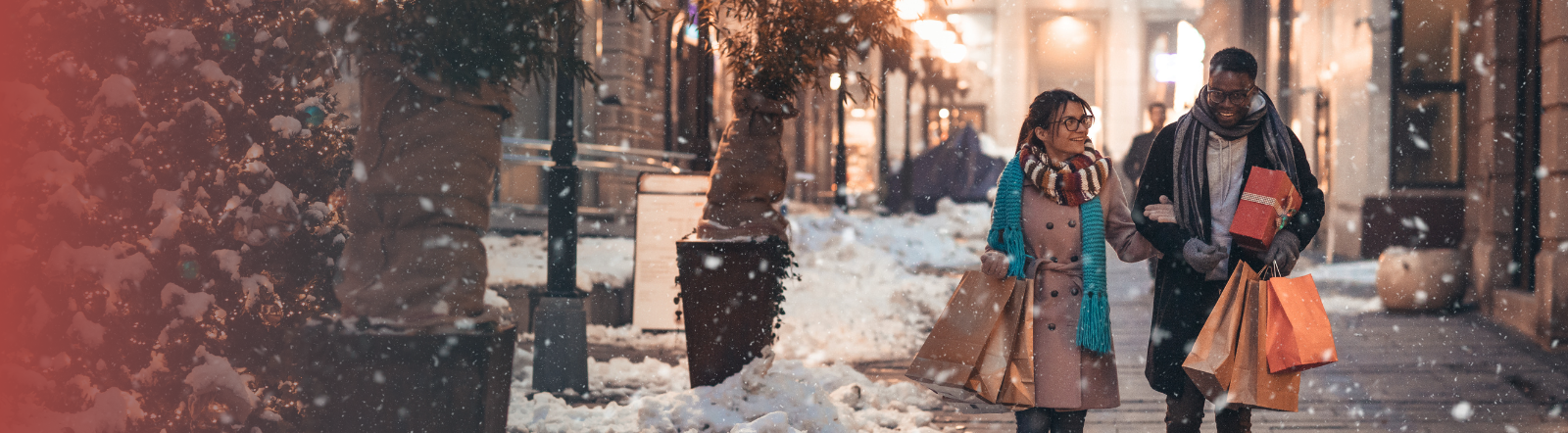 man and woman walking down a sidewalk holding several gift bags